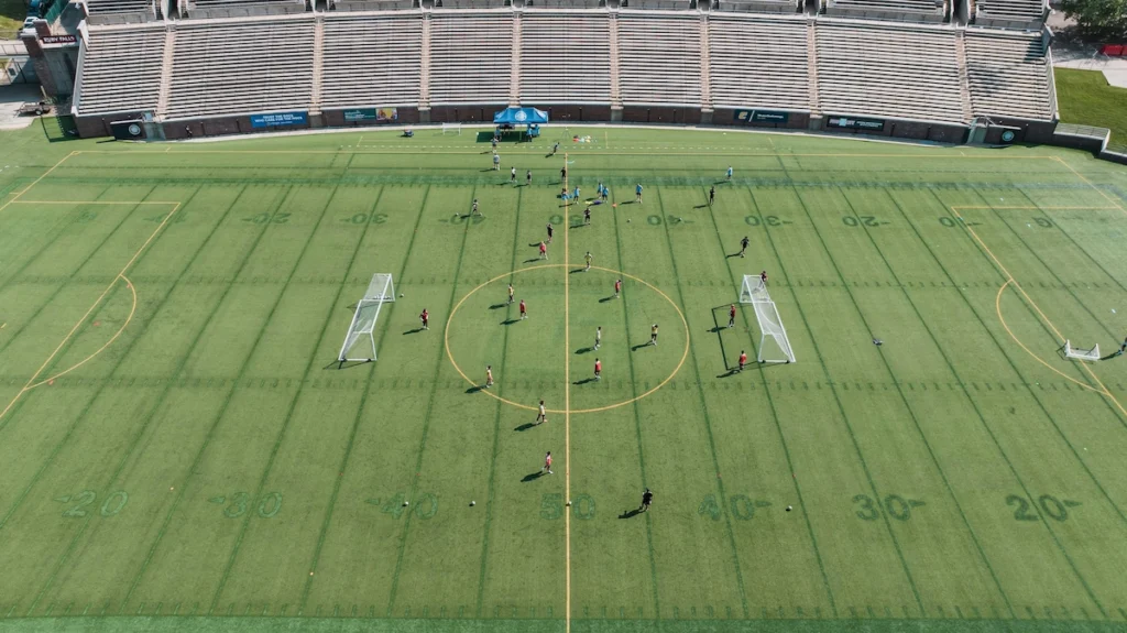 Equipo universitario de fútbol entrenando en el campo durante una sesión de pretemporada