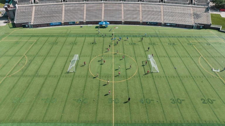 Equipo universitario de fútbol entrenando en el campo durante una sesión de pretemporada