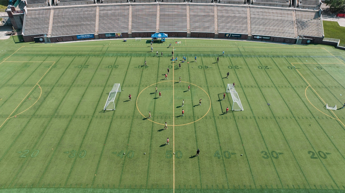 Equipo universitario de fútbol entrenando en el campo durante una sesión de pretemporada