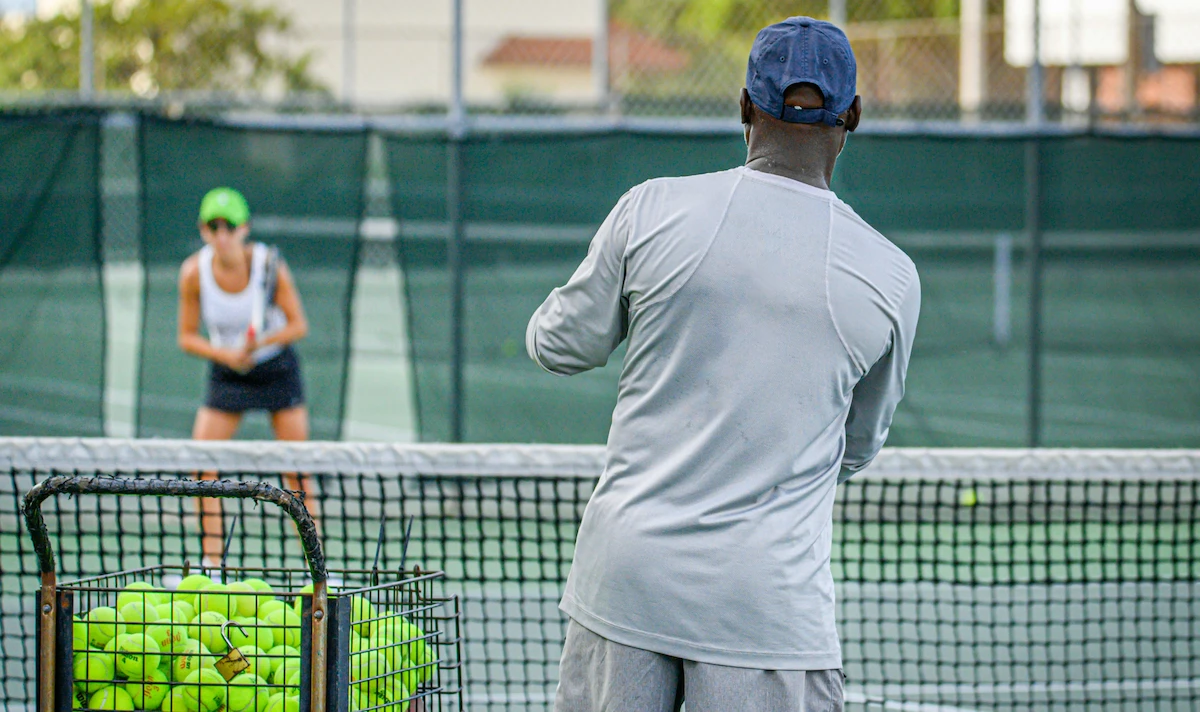 Entrenador de tenis y jugadora en un entrenamiento.